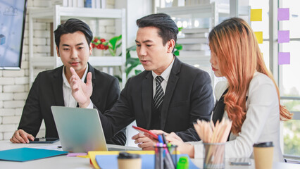 Group of cheerful Asian millennial professional successful male businessman and female businesswoman in formal suit sitting smiling holding fists up together celebrating customer agreement deal done