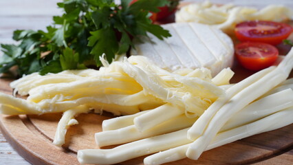 Camembert with String cheese or cheese whip - salty snack cheese with cherry tomatoes and herbs on...