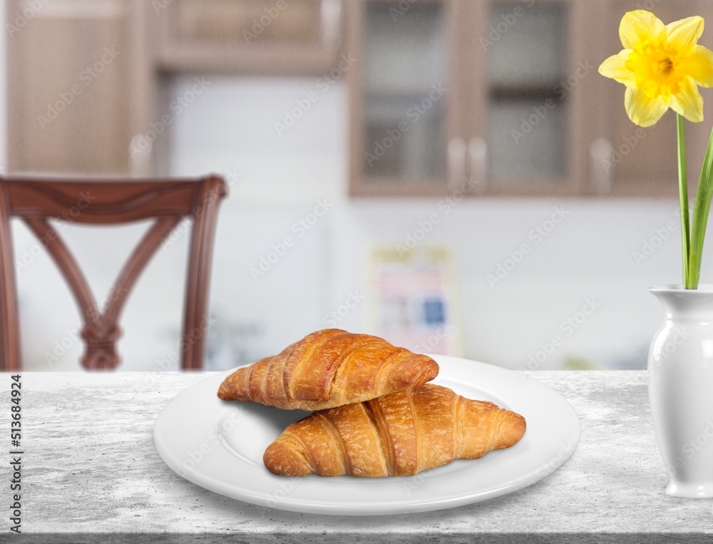 Wall mural croissants in white plate on the kitchen background