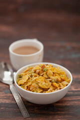 Close-Up of crunchy Indian mixture snacks with hot tea or Coffee time and handmade cookies (biscuits). Studio shoot at declined angle.