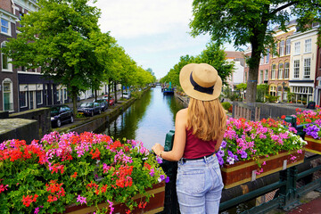 Tourism in Holland. Back view of beautiful fashion girl between flower pots in The Hague,...