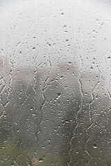 Raindrops run down the window pane. Rainy weather. Soft selective focus.