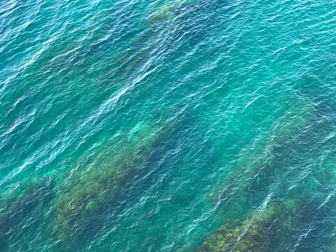 Sea blue turquoise water waves on the beach aerial view. Beautiful seascape.