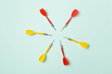 Yellow darts on color background, top view