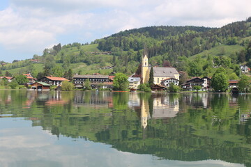 Fototapeta na wymiar See in Bayern mit einer typischen Kirche am Ufer