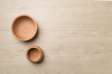 Wooden bowls on wooden background, top view