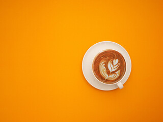 Top view of a fresh coffee cup over an orange background
