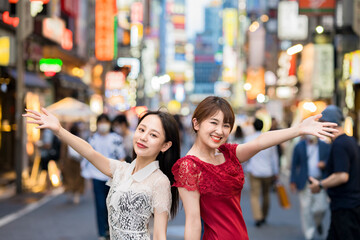 繁華街でポーズをとる女性2人