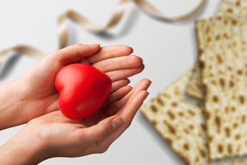 Woman's and man hand holds red shape of heart. Traditional of Jewish Holiday