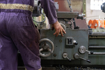 Turner turning an steel metal in a industrial workshop