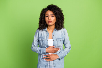 Photo of young woman hands touch belly ill sick spasm suffer gynecology isolated over green color...