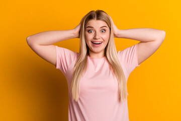 Fototapeta premium Photo of young excited woman hands touch head omg wow discount advertise isolated over yellow color background