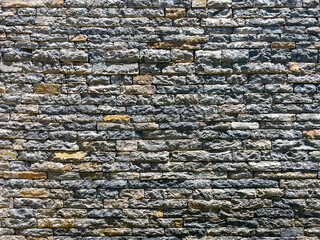 Grey Rough Stone wall texture. Part of old rocky hand crafted background with copy space. Walls made of natural bricks. High quality photo in horizontal composition. Home and office design backdrop