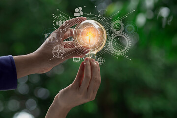 Hand holding light bulb and sustainable development interface icons on green background, Technology...