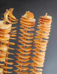 Tornado potatoes chips - spiral french fries on wooden sticks, close-up. Twister potatoes on skewers, popular street food in Prague. - 513697516
