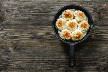 Healthy creamy turkey  meatballs in cast iron skillet on wooden background. Top view, copy space, flat lay.