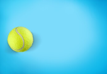 Yellow tennis ball on blue background. Sport poster cards.