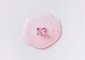 Closeup of pipette with serum, oil, gel with lilac flowers on white background. Skin care, natural...