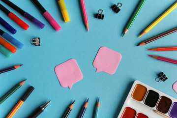 Many stationary supplies on blue background with space for text. Office accessories flat lay. First September, back to school, education, creativity concept. Pens, pencils and paints with copyspace 