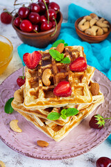 Delicious breakfast with belgian waffles. Waffels with strawberry and berry jam