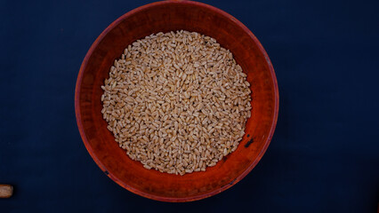 Wooden utensil. Wooden pots. Wheat in Wisden bowl and spoon. Wooden utensils with blue background
