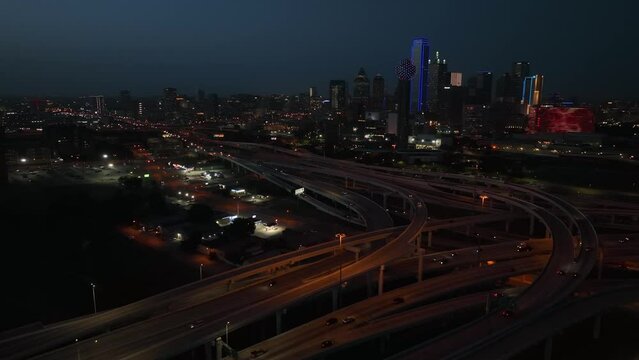 Interstate highway traffic at night in American metropolis. Aerial in evening light.