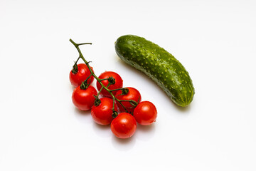 fresh tomato and cucumber with water drops lies on a white background