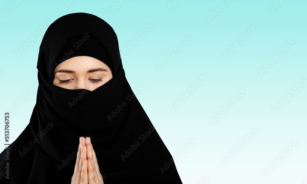 Wall mural praying muslim woman on pastel background. ramadan concept