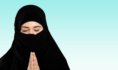 Naklejka premium Praying Muslim woman on pastel background. Ramadan concept
