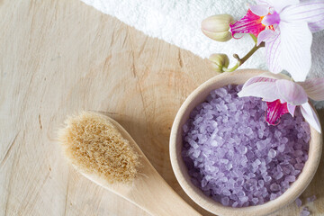 Obraz na płótnie Canvas Bath salt in wooden bowl, body care accessories and pink orchid, spa concept
