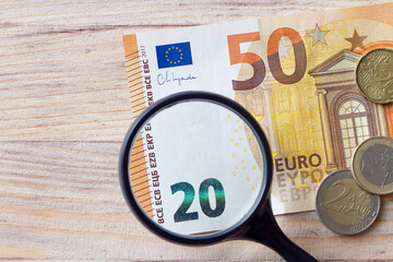 Inflation concept. Decrease in value of money, euro banknote under magnifying glass