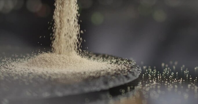 Dry yeast falling on a black surface