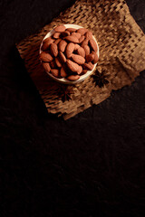 close up some almonds in bowl in dark background