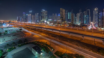 Fototapeta na wymiar Dubai Marina skyscrapers and Sheikh Zayed road with metro railway aerial night timelapse, United Arab Emirates