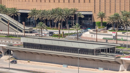 Futuristic building of Dubai tram station and shopping mall behind in Dubai Marina aerial timelapse, United Arab Emirates