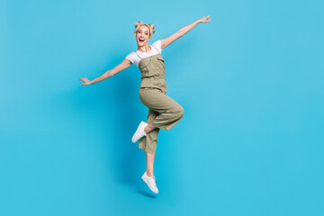 Obraz premium Full size photo of funky young lady jump wear t-shirt grey overall shoes isolated on blue background