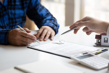 Fototapeta premium Real estate agents negotiate the terms of the home purchase contract and sign the contract legally. Home insurance concept.
