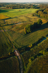 Aerial view on small countryside river in sunset time with old bridge, latvian country side view