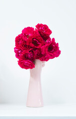 red roses in a vase on a white background