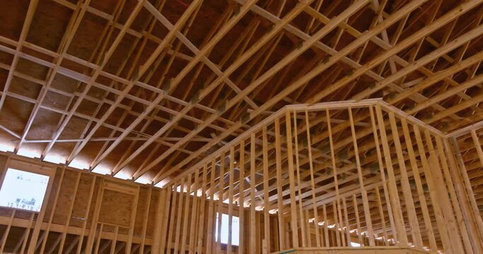 The inside view of new wooden building shows a wood beam framework under construction with a wooden truss.