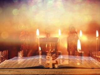 Open bible book on dark black wooden desk table space. Christ gospel literary.