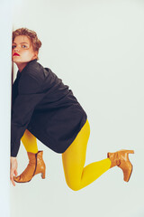 Film effect. Portrait of young stylish girl in yellow tight and black jacket posing, leaning on...