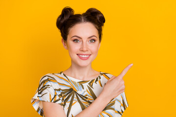 Photo of cute adorable woman wear print t-shirt pointing finger empty space isolated yellow color background