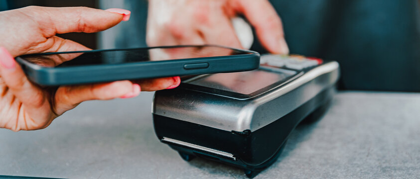 Contactless mobile payment. Payment terminal and smartphone in hands