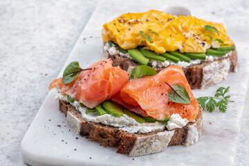 Scrambled eggs with smoked salmon, cream cheese and avocado on toast , Breakfast food
