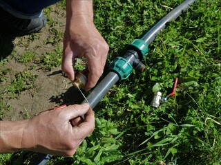 winding plumbing thread on the thread of a water faucet to enhance its tightness, male hands fix...