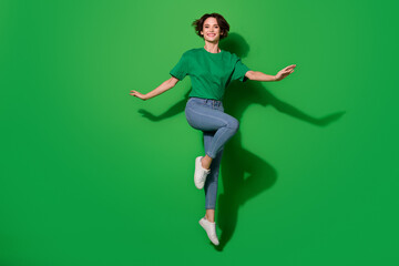 Full length photo of overjoyed glad person jumping have good mood isolated on green color background