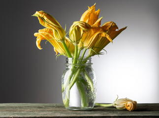 Still life with courgette flowers on the wooden table - 513722792