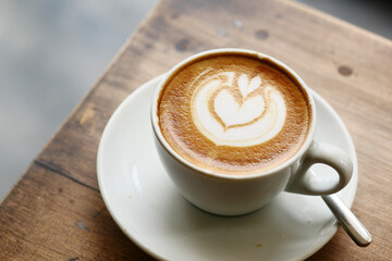 a cup of late coffee with flower shape design on top at cafe 