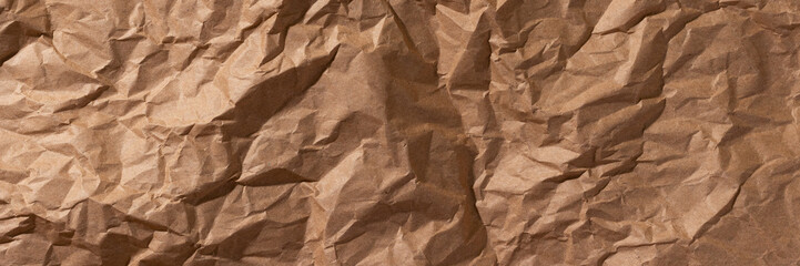 Brown crumpled, wrinkled recycle craft paper texture background banner. Wide panoramic header